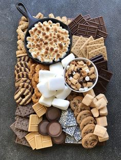 a platter filled with lots of different types of desserts and crackers on top of a table