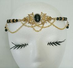 "This beautiful circlet has black glass beads, gold plated accent beads, gold plated chain, brass side accent pieces, brass pendant and black cats eye stone setting with rhinestones. 20\" long can be adjusted to 24\". Lobster clasp." Elegant Handmade Gold Body Jewelry, Adjustable Black Jewelry With Bead Caps, Vintage Gold Headpiece For Evening, Gold Round Crown Headpiece As Gift, Gold Round Crown Headpiece For Gift, Adjustable Gold Beaded Body Jewelry, Gold Gothic Wedding Jewelry, Adjustable Gold Brass Body Jewelry, Elegant Gold Body Jewelry For Festivals