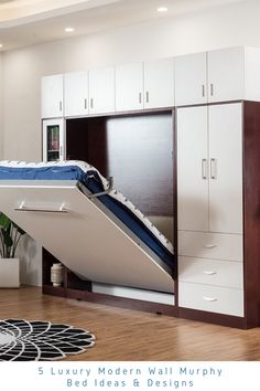 a bed that is in the middle of a room with white cupboards and drawers