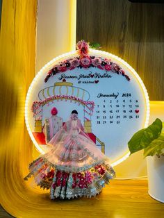 a clock with a bride's dress on it next to a potted plant