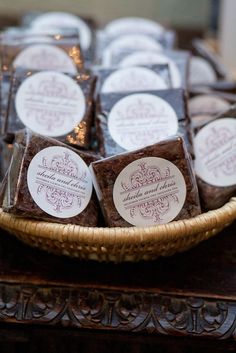 a basket filled with lots of brownies on top of a wooden table covered in labels