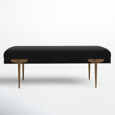 an upholstered bench with wooden legs in black fabric and gold trimmings