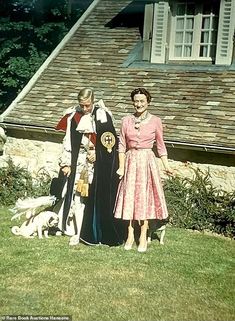 an old photo of two women and a dog in front of a house