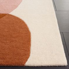 a close up of a rug on the floor with different colors and shapes in it