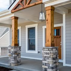 the front porch is covered in wood and has two pillars with columns on each side