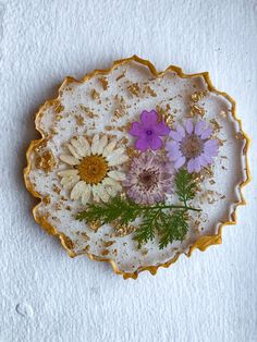 a plate with flowers on it sitting on a white tableclothed surface, in the shape of a flower bowl