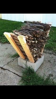 a pile of wood sitting on top of a cement block