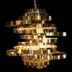 a large chandelier made out of gold foiled metal strips with lights hanging from it