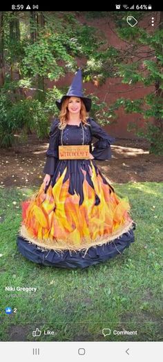 a woman in a witch costume sitting on the grass