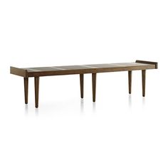 a long wooden table sitting on top of a white floor