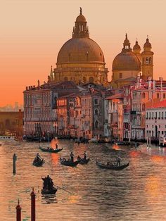 the water is full of gondolas and boats in front of buildings at sunset