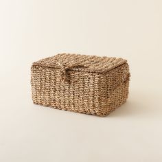 a woven basket with a bow on the top is sitting on a white surface and it's lid is open