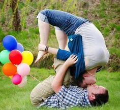 a man and woman are playing with balloons in the grass while one holds on to his head