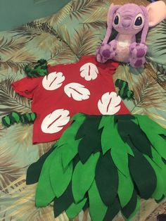 two stuffed animals sitting on top of a bed next to some paper leaves and t - shirts