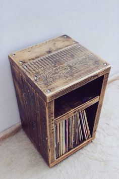 an old wooden box with cd's in it is on the floor next to a wall