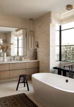 a bathroom with a large white bathtub sitting next to a window