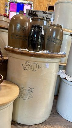 several old fashioned jars are stacked on top of each other in buckets for sale