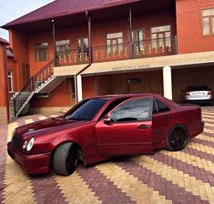 a red car parked in front of a house