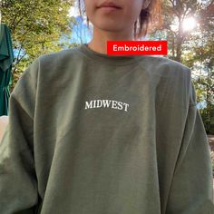 "*SIZES ARE UNISEX* -I'd suggest your usual size for a regular fit, or sizing up for a more relaxed fit. *these sweatshirts are extra comfy when oversized \"Midwest\" embroidered on a cute vintage-style crewneck. A cozy sweatshirt bound to keep you warm in the colder months. A pre-shrunk, classic fit sweater that's made with air-jet spun yarn for a soft feel and reduced pilling. Your new favorite sweatshirt! * 50% cotton, 50% polyester * Pre-shrunk * Classic fit with no center crease * 1x1 athle Oversized Sweater With Embroidered Logo For Fall, Oversized Fall Sweater With Embroidered Logo, Embroidered Logo Tops For Fall Streetwear, Fall College Embroidered Tops, Embroidered Fall Tops For College, Oversized Sweatshirt With Embroidered Graphics For Fall, Oversized Sweatshirt With Embroidered Logo For Fall, Green Casual Sweatshirt With Embroidered Text, Casual Green Sweatshirt With Embroidered Text