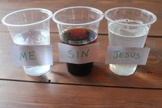 three plastic cups filled with liquid sitting on top of a wooden table