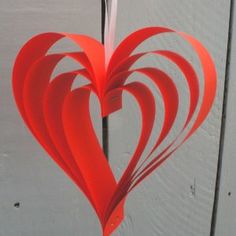 a red paper heart hanging from a hook