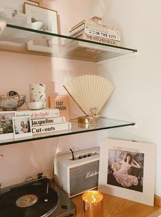 an old record player sitting on top of a wooden table next to a shelf filled with books