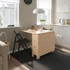 a kitchen with a table, chair and clock on the wall