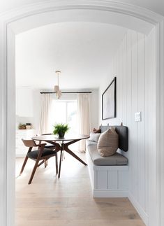 an open door leading to a dining room with a table and bench in the center