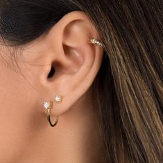 "Minimal with an edge, these stud earrings are the perfect subtle accent to your everyday ear stack. They utilize only one curve, making them more versatile since they can be worn like a stud to hug the lower part of the earlobe, but can also be flipped for an edgier look to curve over the inner ear. * D E T A I L S * ∙ Sold as a PAIR ∙ Material: .925 Sterling Silver or 18K Gold Plated over .925 Sterling Silver ∙ Stone: White Zirconia ∙ Dimensions: Height: 15mm // Zirconia: 4mm ∙ Hypoallergenic Suspender Earrings, Ear Lobe Piercings, Types Of Ear Piercings, Dainty Gold Earrings, Ear Piercing Ideas, Cool Ear Piercings, Inner Ear, Cool Piercings, Cute Piercings