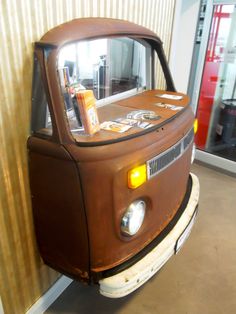 an old brown truck parked next to a wall with a sign on the front window