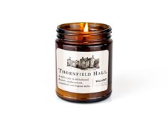 a candle with a label on it sitting in front of a white background that says thornfield hall