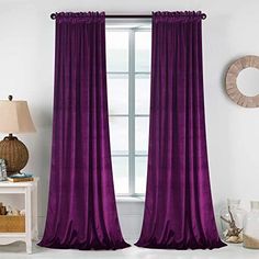 the purple curtains in this room are ready to be hung