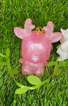 two plastic animals sitting in the grass next to each other on top of green leaves