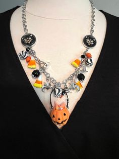 a woman wearing a black shirt and a silver chain necklace with halloween charms on it