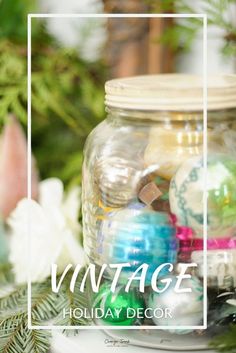 a glass jar filled with ornaments on top of a table