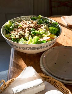 a salad in a bowl with cheese on the side