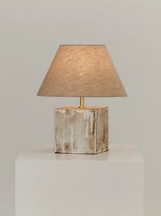 a lamp sitting on top of a white block