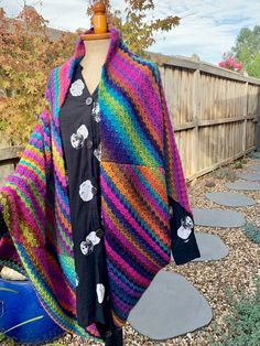 a woman's multicolored knitted ponchy with skulls on it