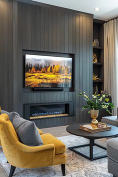 a living room filled with furniture and a flat screen tv mounted on the wall above a fire place