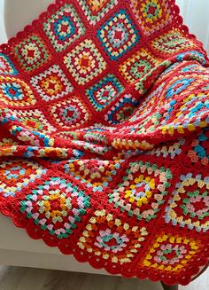 a red crocheted blanket sitting on top of a window sill