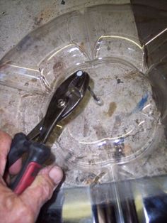 a pair of pliers are being held in front of a plastic container