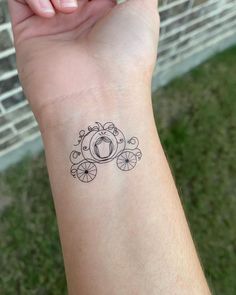 a woman's wrist with a small tattoo design on the left side of her arm