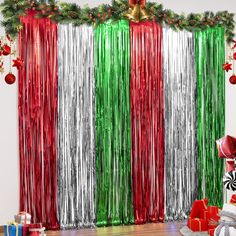 a room decorated for christmas with red, green and silver tinsel curtain backdrops