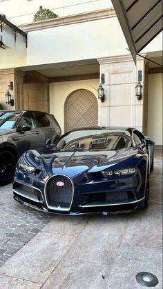 two bugatti cars parked in front of a building with an open garage door