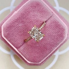 a pink velvet case with a diamond ring on it