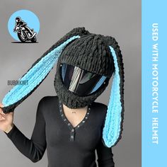 a woman wearing a knitted hat with blue ears on her head and the words, u - shaped motorcycle helmet