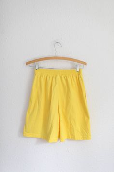 "material: jersey cotton, fits small used vintage condition  actual measures: waist:264-28\" rise:13\" inseam:6\" total length:18\"" 90s Style Relaxed Fit Cotton Shorts, Yellow Athletic Shorts For Spring, Yellow Athletic Shorts With Elastic Waistband, Yellow Cotton Pajama Shorts For Spring, Yellow Athletic Shorts With Built-in Shorts For Spring, Yellow Cotton Pajama Shorts With Elastic Waistband, Retro Yellow Short Bottoms, Yellow Cotton Shorts For Streetwear, Yellow Relaxed Fit High-waisted Shorts