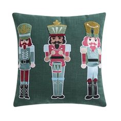 three nutcrackers on green linen pillow