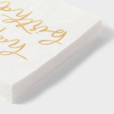 a stack of white napkins with gold foil lettering on them that says happy new year