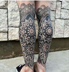 the legs and ankles of a woman with tattoos on her body are covered in intricate designs